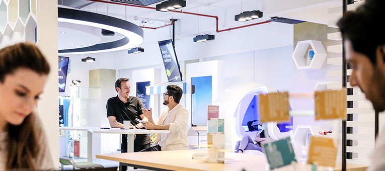 Two employees having a conversation at one of our spaces in Dubai Outsource City