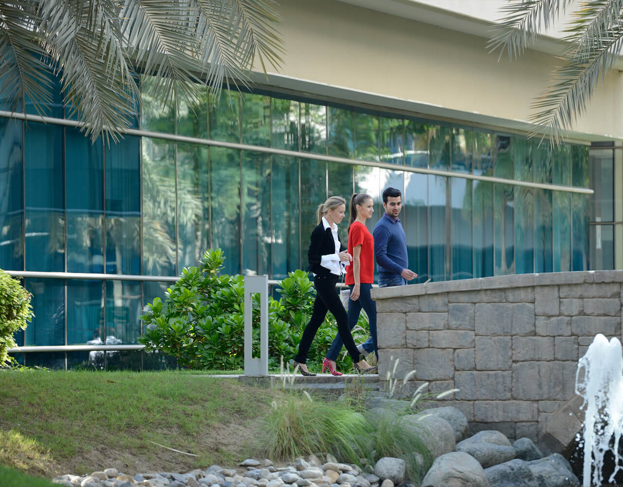  Three people walking past the waterfront at Dubai Outsource City